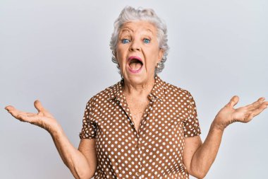 Yaşlı, gri saçlı, sıradan kıyafetler giyen, çılgın kutlamalar yapan ve başarıyı kolları açık, gözleri açık, heyecanlı bir şekilde kutlayan bir kadın. Kazanan konsept 