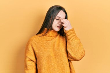 Günlük kıyafetler giyen genç İspanyol kız yorgun burnu ve gözleri ovuşturup yorgun ve baş ağrısı çekiyor. Stres ve hüsran kavramı. 