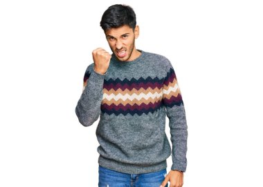 Genç ve yakışıklı bir adam öfkeyle bağırırken kızgın ve kızgın yumruk kaldırıyor. öfke ve agresif konsept. 