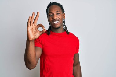 Saçları örgülü, gülümseyerek gülümseyen Afro-Amerikan bir adam el ve parmaklarıyla 