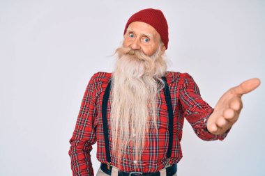 Gri saçlı, uzun sakallı, hippi görünümlü, yün şapkalı, dostane bir şekilde el sıkışan yaşlı bir adam. başarılı iş. 