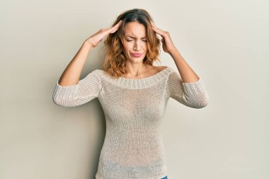 Kafası havada, günlük kıyafetler giyen beyaz bir kadın. Stres yüzünden baş ağrısı çekiyor. migren ağrısı. 