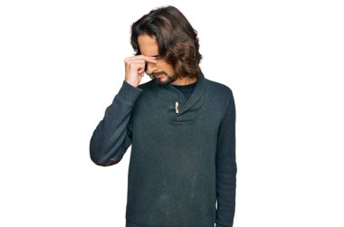 Günlük kıyafetler giyen genç İspanyol adam yorgun burnu ve gözleri ovuşturup yorgun ve baş ağrısı çekiyor. Stres ve hüsran kavramı. 