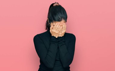 Ağlarken yüzünü ellerle kapatan, günlük kıyafetler giyen genç İspanyol kadın. depresyon kavramı. 