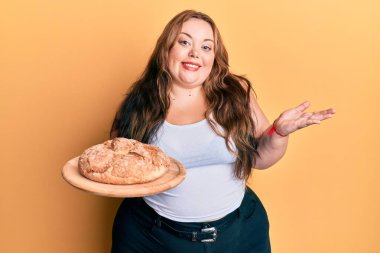 Ayrıca beyaz bir kadın elinde ekmek tutarak başarıyı mutlu bir gülümsemeyle kutluyor ve kazanan el kaldırarak ifade ediyor. 