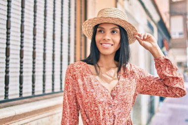 Genç Afro-Amerikan turist kadın tatilde gülümseyerek şehirde mutlu bir şekilde yürüyor..