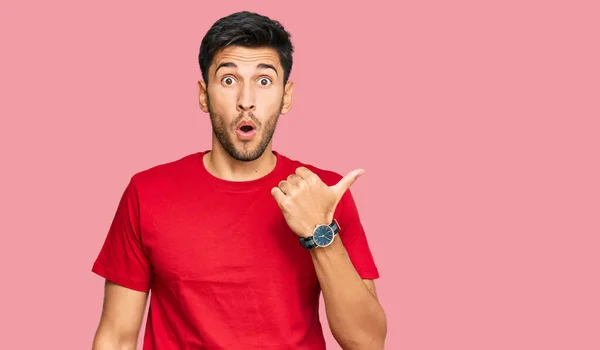 Young Handsome Man Wearing Casual Red Tshirt Surprised Pointing Hand — Foto de Stock