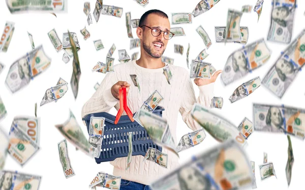 Young Handsome Man Holding Supermarket Shopping Basket Pointing Thumb Side — Stock Photo, Image
