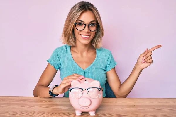 Beautiful Caucasian Woman Holding Piggy Bank Glasses Smiling Happy Pointing — Stock Photo, Image