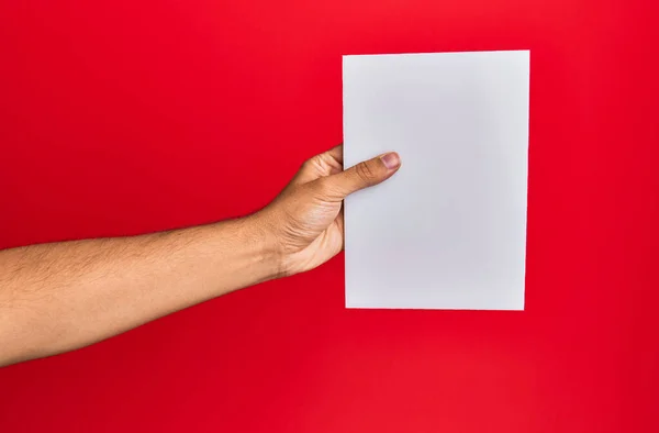 Mano Joven Hispano Sosteniendo Bandera Vacía Sobre Fondo Rojo Aislado — Foto de Stock