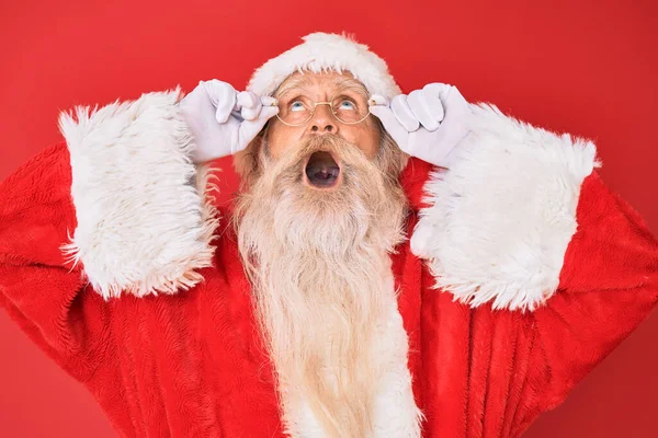 Staruszek Siwymi Włosami Długą Brodą Kostiumie Świętego Mikołaja Trzymający Okulary — Zdjęcie stockowe