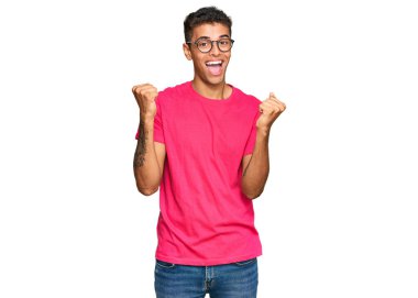 Genç, yakışıklı, Afro-Amerikalı günlük kıyafetler giymiş gururla bağıran, zaferi kutlayan ve kollarını kaldırarak heyecanlanan bir adam. 