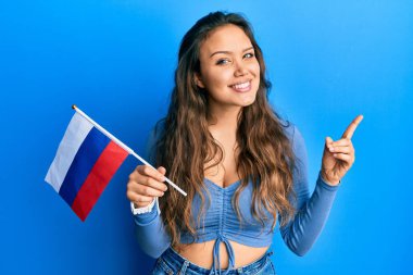 Rus bayrağını tutan genç İspanyol kız mutlu bir şekilde gülümsüyor. 