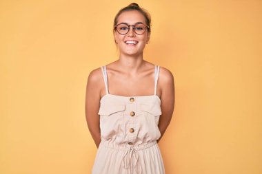 Yüzünde mutlu ve havalı bir gülümseme olan beyaz bir elbise giyen güzel bir kadın. şanslı kişi. 