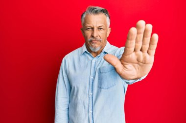 Orta yaşlı, gri saçlı, günlük kıyafetler giyen bir adam avucunun içi gibi şarkı söylemeyi kesiyor. Yüzünde olumsuz ve ciddi bir jest olan uyarı ifadesi. 