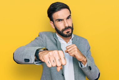 Latin kökenli genç bir adam iş kıyafetleri içinde dövüşmek için yumruk atıyor agresif ve öfkeli saldırı, tehdit ve şiddet. 