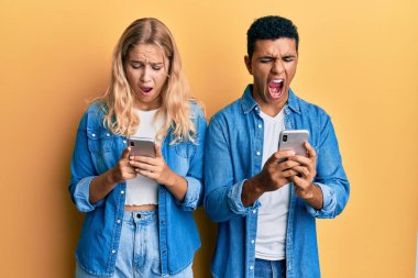 Irklar arası genç bir çift, kızgın ve kızgın bir şekilde öfkeli bir şekilde bağırıyor. Öfkeyle bağırıyor. öfke ve agresif konsept. 