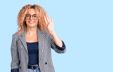 Kıvırcık saçlı, iş ceketli, gözlüklü, dört numaralı parmaklarıyla işaret eden, kendinden emin ve mutlu genç bir kadın.. 