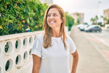 Güzel orta yaşlı İspanyol kadın dışarıda mutlu bir şekilde gülümsüyor.