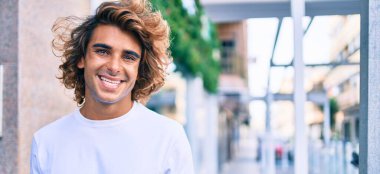 Genç, yakışıklı, gülümseyen bir İspanyol. Şehrin caddesinde mutlu bir şekilde yürüyor.