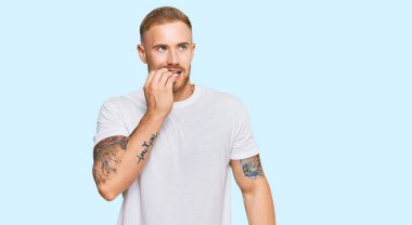 Günlük kıyafetler giyen genç İrlandalı gergin ve gergin görünüyor. Ağzı tırnak yiyen eller. anksiyete. 