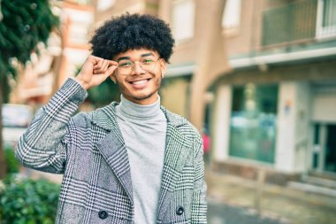 Genç Afrikalı Amerikalı iş adamı şehirde mutlu mesut dikiliyor..