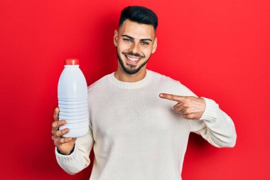 Sakallı, litrelik süt şişesi tutan genç İspanyol adam mutlu bir şekilde elini ve parmağını gösterdi. 