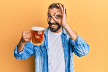 Uzun saçlı ve sakallı çekici bir adam. Yarım litre bira içiyor. Gülümsüyor. 