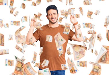 Günlük kıyafetler giyen genç İspanyol adam umut ve gözlerin kapalı gülümseyerek bana işaret etti. Şans ve batıl inançlar.