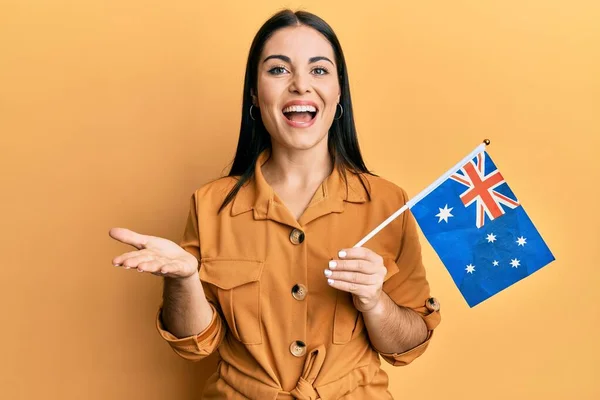 若いですブルネット女性を保持しているオーストラリアのフラグを祝います達成とともに幸せな笑顔と勝者式とともに上げ手 — ストック写真
