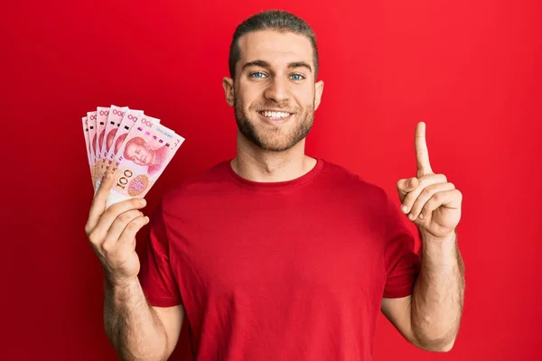 Joven Hombre Caucásico Sosteniendo Billetes Chinos Yuan Sonriendo Con Una — Foto de Stock