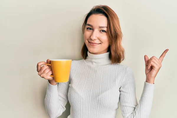 Jonge Blanke Vrouw Houdt Koffie Glimlachend Gelukkig Wijzend Met Hand — Stockfoto