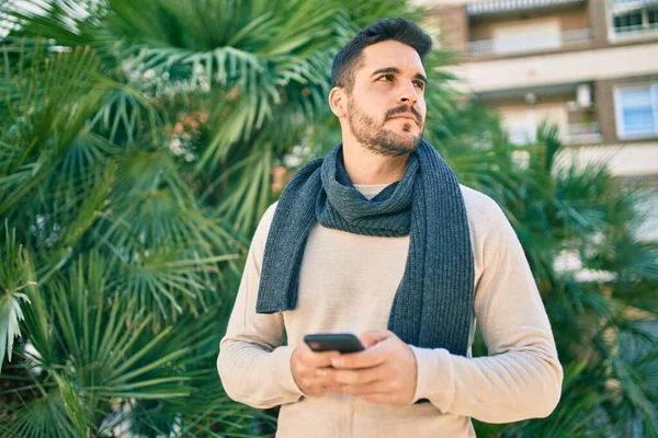 Joven Hombre Hispano Con Expresión Seria Usando Smartphone Parque —  Fotos de Stock