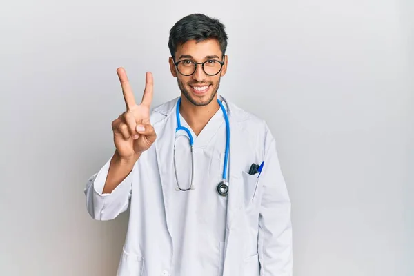 Młody Przystojny Mężczyzna Noszący Mundur Lekarza Stetoskop Pokazujący Wskazujący Palcami — Zdjęcie stockowe