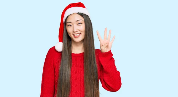 若いです中国の女性身に着けていますクリスマスの帽子ショーと指摘指番号4ながら笑顔自信と幸せ — ストック写真