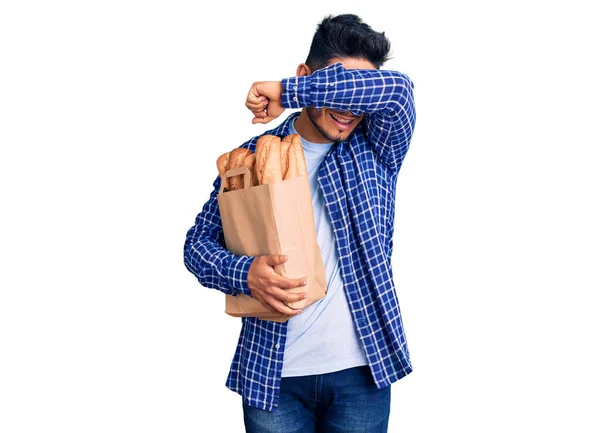 Guapo Joven Latinoamericano Sosteniendo Bolsa Papel Con Pan Sonriente Alegre —  Fotos de Stock