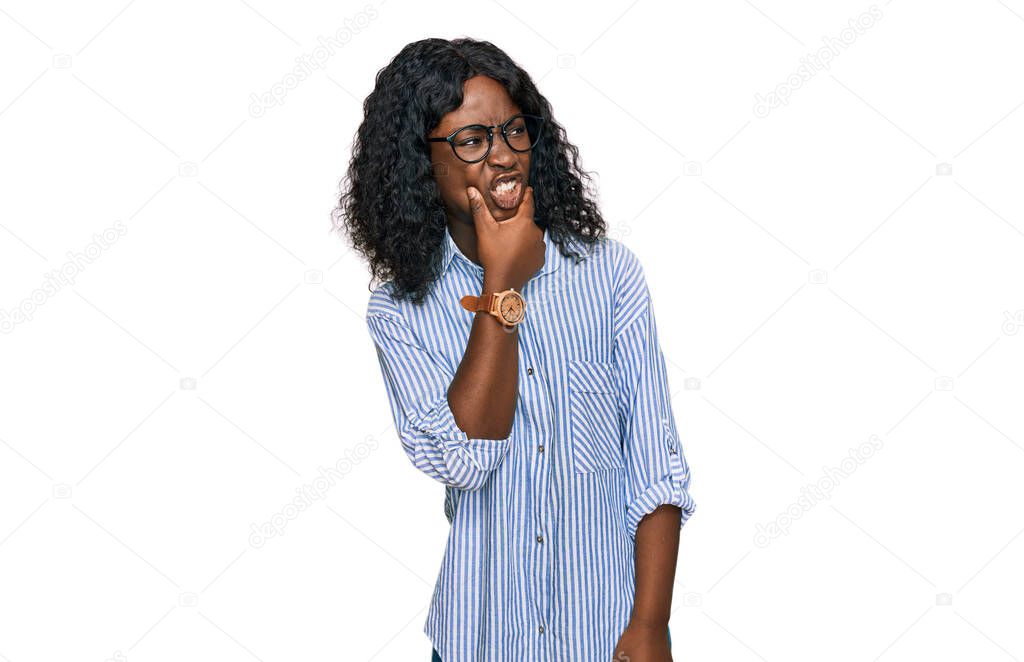 Beautiful african young woman wearing casual clothes and glasses thinking worried about a question, concerned and nervous with hand on chin 