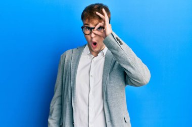 Zarif kıyafetler ve gözlük takan genç beyaz adam şaşırmış yüz ve gözlerle parmaklarından bakıyor. İnançsız ifade. 