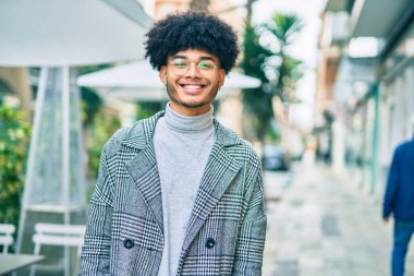 Genç Afrikalı Amerikalı iş adamı şehirde mutlu mesut dikiliyor..