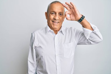 Yakışıklı, beyaz tişört giyen, olumlu gülümseyen, el ve parmaklarıyla 