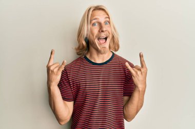 Kafkasyalı, uzun saçlı genç adam rock hareketi yapıyor. Çılgınca kutlama yapıyor ve başarıya hayret ediyor. Gözleri açık, heyecanla haykırıyor.. 