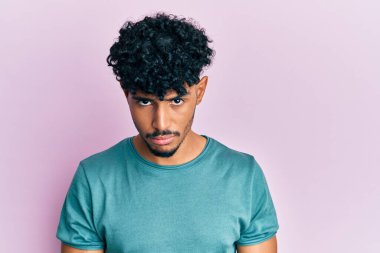 Gündelik kıyafetler giyen, kuşkucu ve gergin genç Arap yakışıklı bir adam, sorun yüzünden surat asıyor. negatif kişi. 