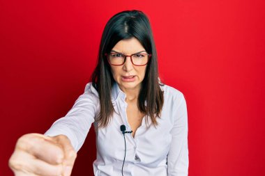 Latin kökenli genç bir kadın mikrofon kullanıyor. Öfkeyle bağırıyor, öfkeyle bağırıyor ve el kaldırıyor. 