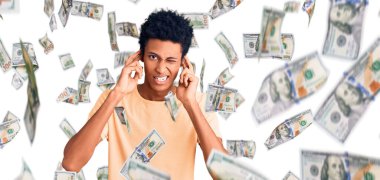 Genç Afro-Amerikan adam gündelik kıyafetler giyip yüksek sesli müzik sesi için kulaklarını parmaklarıyla kapatıyor. sağır kavramı.