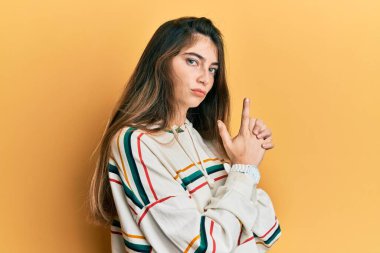 Kafkasyalı genç bir kadın gündelik kıyafetler giyiyor. Elinde sembolik bir silah var. El hareketleriyle cinayet silahlarıyla oynuyor. 