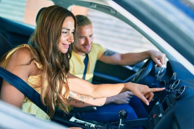 Mutlu bir şekilde gülümseyen genç çift ve GPS akıllı telefonu kullanıyorlar..