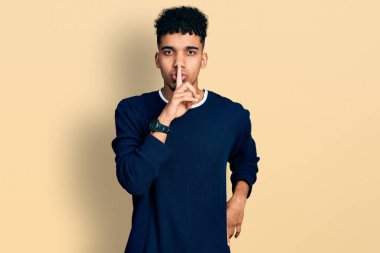 Gündelik giysiler giymiş genç Afro-Amerikan bir adam sessiz olmak istiyor. sessizlik ve gizli konsept. 