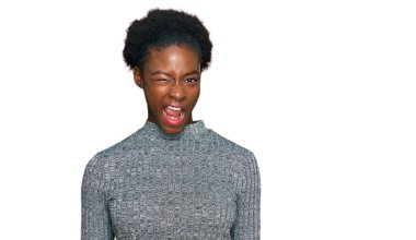 Genç Afro-Amerikan kızı, günlük giysiler içinde kameraya seksi bir ifadeyle bakıyor, neşeli ve mutlu bir yüzle.. 