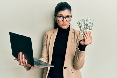 İş tarzı dizüstü bilgisayar giyen İspanyol genç bir kadın ve 50 avro şüpheci ve gergin, sorun yüzünden surat asıyor. negatif kişi. 