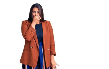 Zarif kıyafetler giyen genç, güzel esmer kadın pis ve iğrenç bir koku alıyor. Nefesini burnunda tutuyor. Kötü kokuyor. 